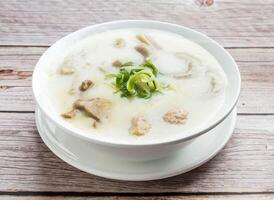 pork meatballs and pork innards congee served in dish isolated on wooden table top view hong kong food photo