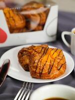 melocotón danés Pastelería soplo servido en plato con taza de negro café aislado en servilleta con tenedor y cuchillo lado ver de francés desayuno horneado comida articulo en gris antecedentes foto