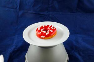 Strawberry Glazed Donut served in plate isolated on background side view of baked food breakfast on table photo