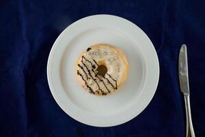 White Chocolate Donut served in plate isolated on blue background top view of baked food breakfast on table photo