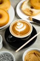 Hot Butterscotch Latte Art Coffee served in cup with plain donuts, sugar and knife isolated on napkin side view cafe breakfast photo