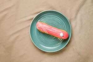 Strawberry Eclair served in plate isolated on napkin top view of cafe baked food on background photo