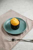 Vanilla Muffin cup cake served in plate with fork isolated on napkin side view of cafe baked food on background photo