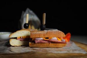 Robust Roast Beef Cheddar Sandwich with mayonnaise dip with fries served in wooden board isolated on napkin side view of breakfast food photo