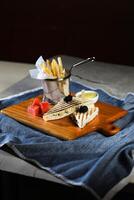 Grilled Chicken Sandwich with fries bucket served in wooden board isolated on napkin side view of breakfast food photo