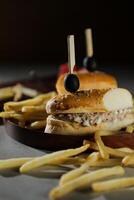 Tuna Egg Sandwich with fries and mayonnaise dip served in wooden board isolated on dark background side view of breakfast food photo