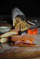 Robust Roast Beef Cheddar Sandwich with mayonnaise dip with fries served in wooden board isolated on napkin side view of breakfast food photo