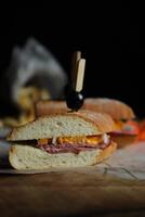 Robust Roast Beef Cheddar Sandwich with mayonnaise dip with fries served in wooden board isolated on napkin side view of breakfast food photo