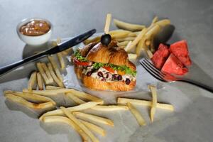 Harvest Chicken Sandwich with french fries and mayonnaise dip isolated on napkin side view of breakfast food photo