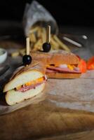Robust Roast Beef Cheddar Sandwich with mayonnaise dip with fries served in wooden board isolated on napkin side view of breakfast food photo