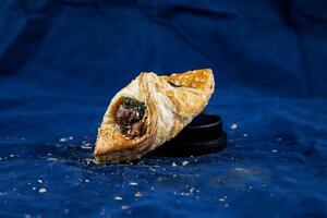 Spinach Puff with Sweet Corn isolated on blue background side view of savory snack food photo
