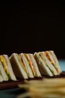 Assorted Club Sandwich isolated on wooden with mayonnaise dip and french fries bucket board side view of italian fast food on background photo