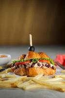 Harvest Chicken Sandwich with french fries and mayonnaise dip isolated on napkin side view of breakfast food photo