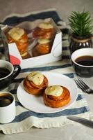 canela rodar servido en plato con taza de negro café con cuchillo y tenedor aislado en servilleta lado ver de francés desayuno horneado comida articulo foto