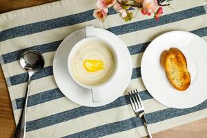 Cream Chicken soup with bread served in bowl isolated on napkin top view of chinese soup photo