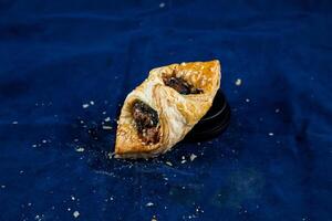 Spinach Puff with Sweet Corn isolated on blue background side view of savory snack food photo