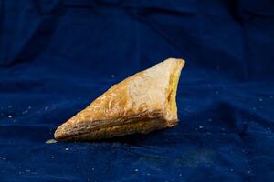 Vegetable Patties or samosa isolated on blue background side view of savory snack food photo