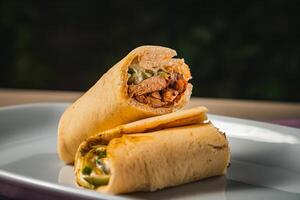 árabe pollo shawarma lleno con carne, Pepino y mayonesa servido en plato aislado en mesa lado ver de libanés comida foto