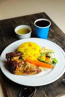 Rice with chicken Roast Meal with salad served in plate with sauce, cold drink, spoon and fork isolated on wooden board side view of thai food photo