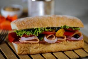 ciabatta ahumado jamón emparedado aislado en de madera con mayonesa inmersión y francés papas fritas Cubeta tablero lado ver de italiano rápido comida en gris antecedentes foto