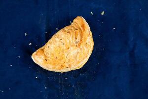 Beef Turnover isolated on blue background top view of savory snack food photo