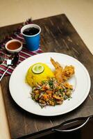 Hot Lemony Chicken Rice Meal served in plate with sauce, cold drink, spoon and fork isolated on wooden board side view of thai food photo