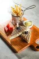 Grilled Chicken Sandwich with fries bucket served in wooden board isolated on napkin side view of breakfast food photo