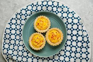 Lemon Tart muffin cup cake served in plate isolated on napkin top view of cafe baked food on background photo