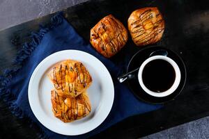 melocotón danés Pastelería soplo servido en plato con taza de negro café aislado en servilleta parte superior ver de francés desayuno horneado comida articulo en gris antecedentes foto