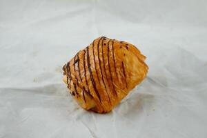 Chocolate Croissant isolated on grey background side view of french breakfast baked food item on grey background photo