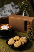 Crunchy cookies biscuits served in plate with cookie box, coffee latte art isolated on table side view of american cafe baked food photo