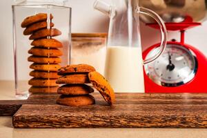 sabroso chocolate Galleta con jarra de Leche servido en de madera tablero lado ver de sano desayuno en mesa foto