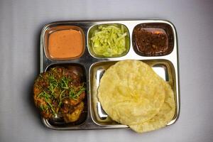 en chaap con lucchi, Chuntney, salsa y chile inmersión servido en thali plato aislado en antecedentes parte superior ver de bangladeshi comida conjunto menú foto