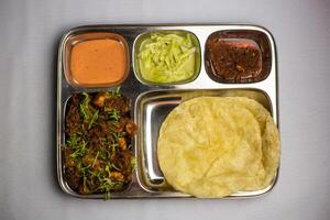 Chicken Masala chaap with Lucchi, chuntney, sauce and chilli dip served in thali platter isolated on background top view of bangladeshi food set menu photo