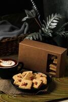 Crunchy cookies biscuits served in plate with cookie box, coffee latte art isolated on table side view of american cafe baked food photo