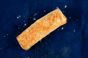 Beef Puff Roll isolated on blue background top view of savory snack food photo