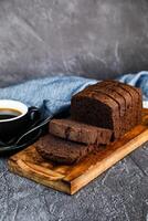 chocolate pastel rebanada servido en de madera tablero con taza de negro café aislado en servilleta lado ver de francés desayuno horneado comida articulo en gris antecedentes foto