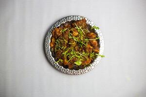 picante pollo condimento chaap con cilantro servido en plato aislado en antecedentes parte superior ver de bangladesí, indio y pakistaní tradicional picante comida foto