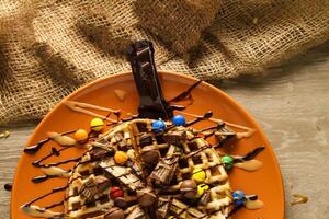 Waffle with Caramel and mix Chocolate served in dish isolated on table top view of cafe snack photo