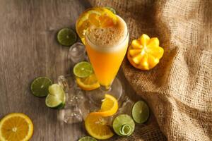 Fresh Orange Juice with lemon and ice cube served in disposable glass isolated on table side view of healthy morning juice drink photo