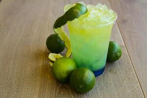 blue lemon soda with ice served in disposable glass isolated on table side view of healthy drink photo