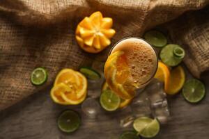 Fresh Orange Juice with lemon and ice cube served in disposable glass isolated on table top view of healthy morning juice drink photo