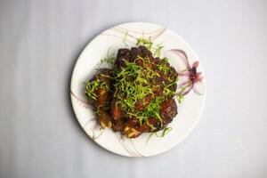 Grill Chicken topping with coriander served in plate isolated on background top view of bangladeshi, indian and pakistani traditional spicy food photo