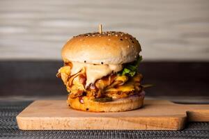 chicken melted cheese burger isolated on wooden board top view of fastfood photo