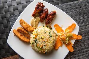 fried rice, chicken wings, Potato wedges and salad served in dish top view of fastfood photo