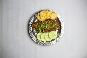 picante carne de vaca chaap con tomate y Pepino servido en plato aislado en antecedentes parte superior ver de bangladesí, indio y pakistaní tradicional picante comida foto