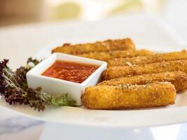 Cheese Fingers sticks with chilli sauce served in dish isolated on table side view of arabic fastfood photo