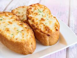 GARLIC BREAD TOPPED WITH CHEESE served in dish isolated wooden table top view arabic food appetizer photo