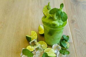 lemon mint smoothie served in disposable glass isolated on table side view of healthy morning smoothie drink photo