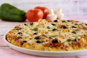 Tuna Fish Pizza topping with capsicum, mushroom, tomato and olives served in dish isolated on table side view of arabic fastfood photo